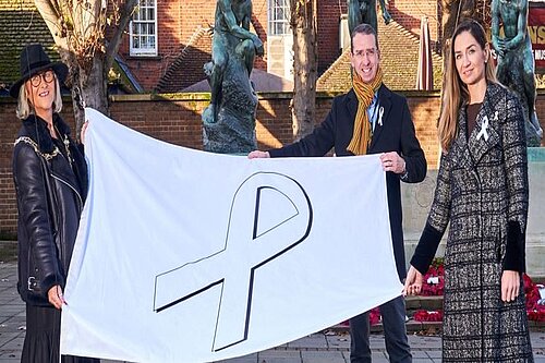 Peter Aga and Amanda hold up the white ribbon flag
